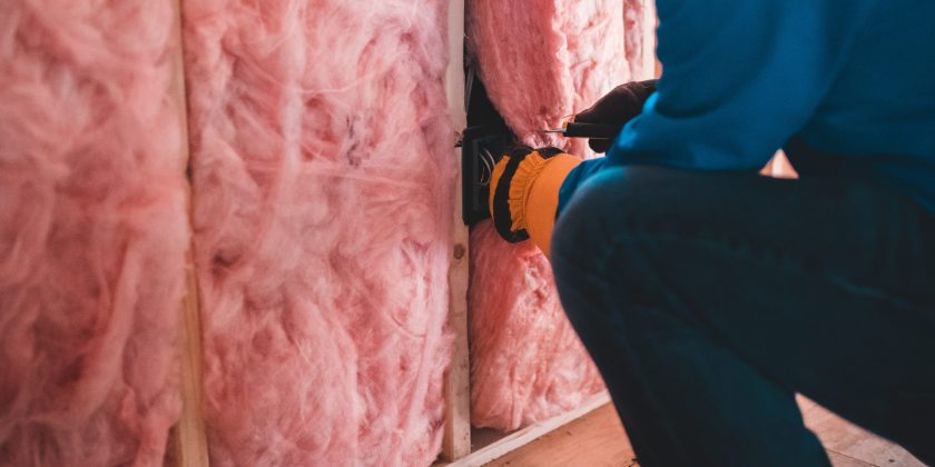 person installing insulation in a house